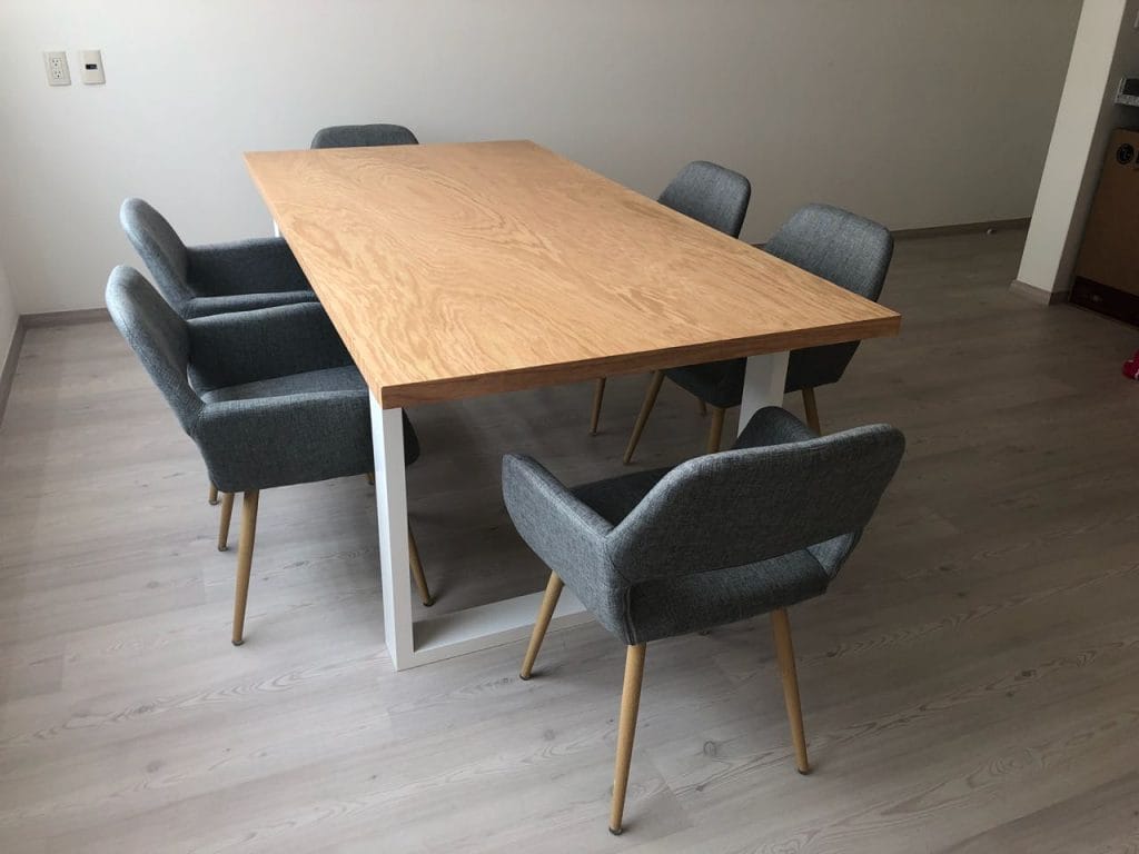 Comedor de diseño minimalista hecho a medida en CDMX, con mesa de encino natural y sillas tapizadas.