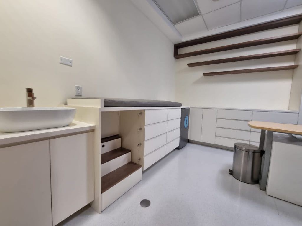 Muebles a medida para consultorio pediátrico con almacenaje, camilla y repisas – proyecto Barniture