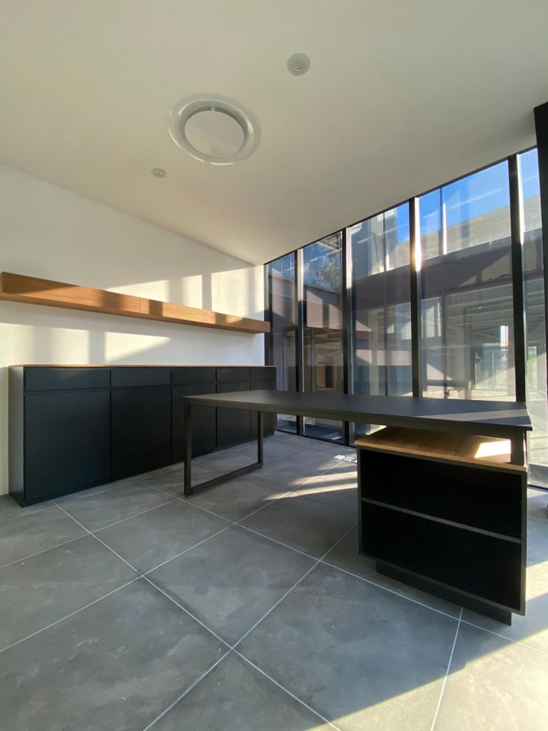 Escritorio moderno con mueble de almacenaje y repisa de madera en oficina de abogados – Barniture