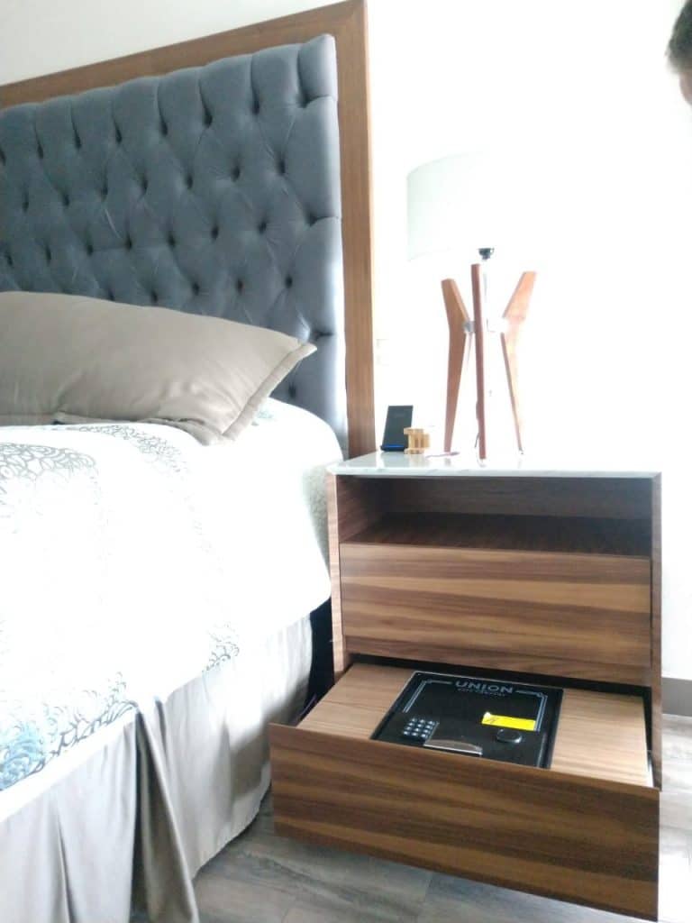 Recámara personalizada con cabecera tapizada y buró de madera a medida, diseñada para mayor funcionalidad y estilo.