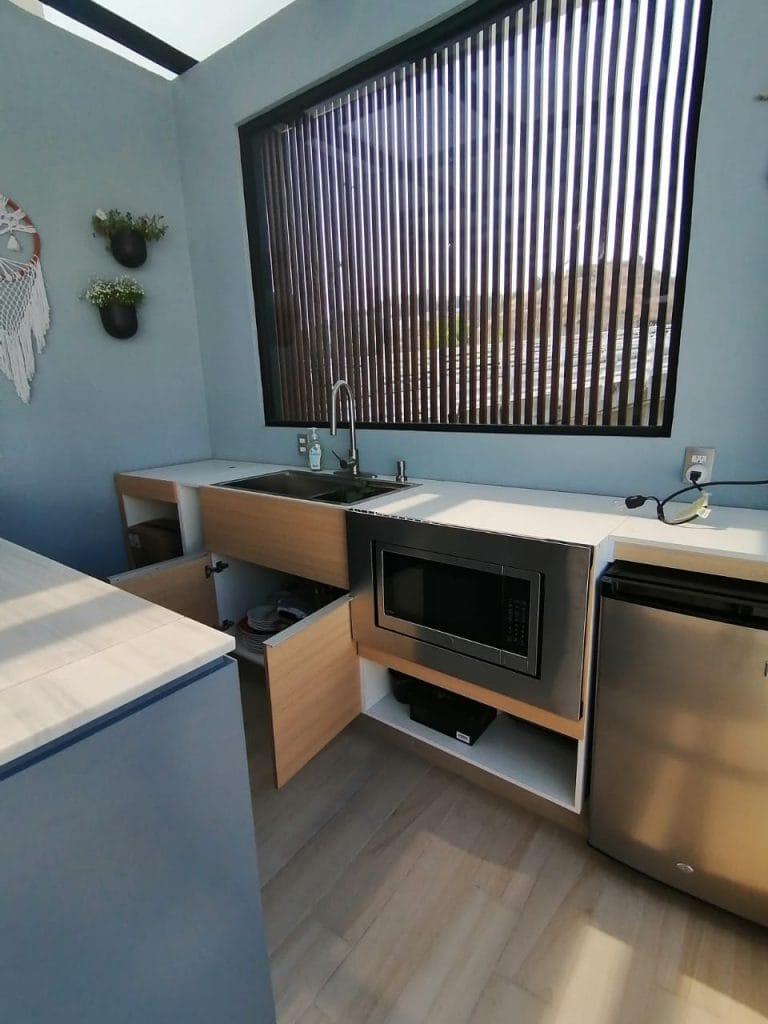 Cocina exterior a medida con diseño funcional en terraza moderna, ideal para espacios pequeños.