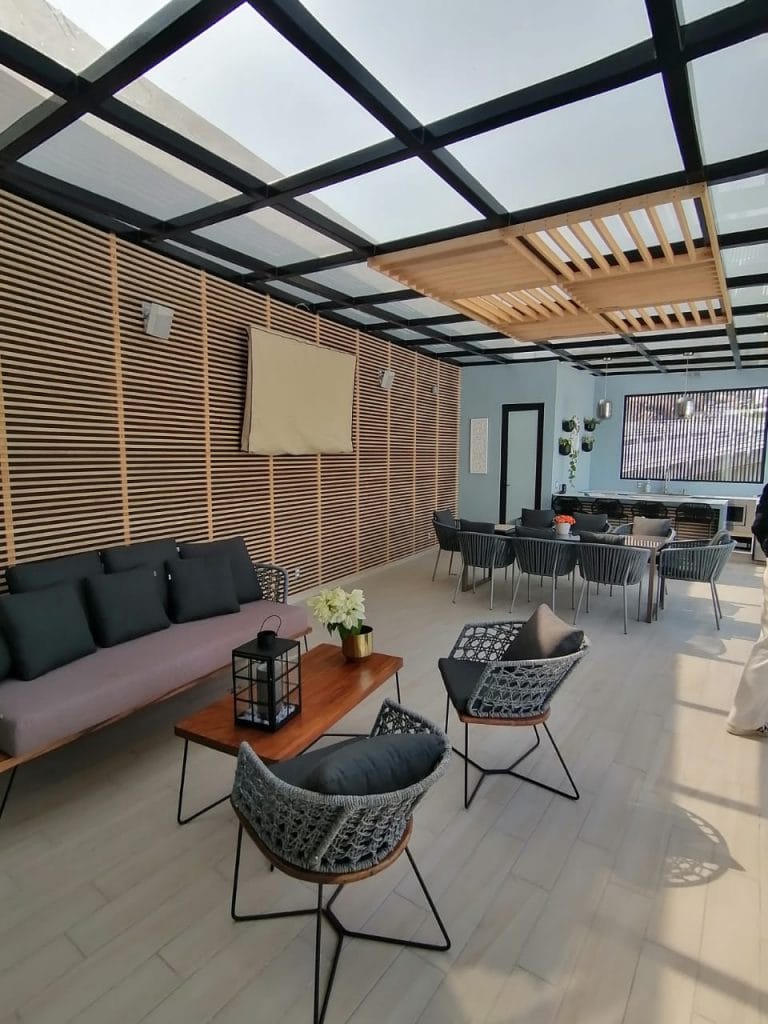 Terraza diseñada por Barniture con sala, comedor y acabados en madera, perfecta para reuniones familiares.